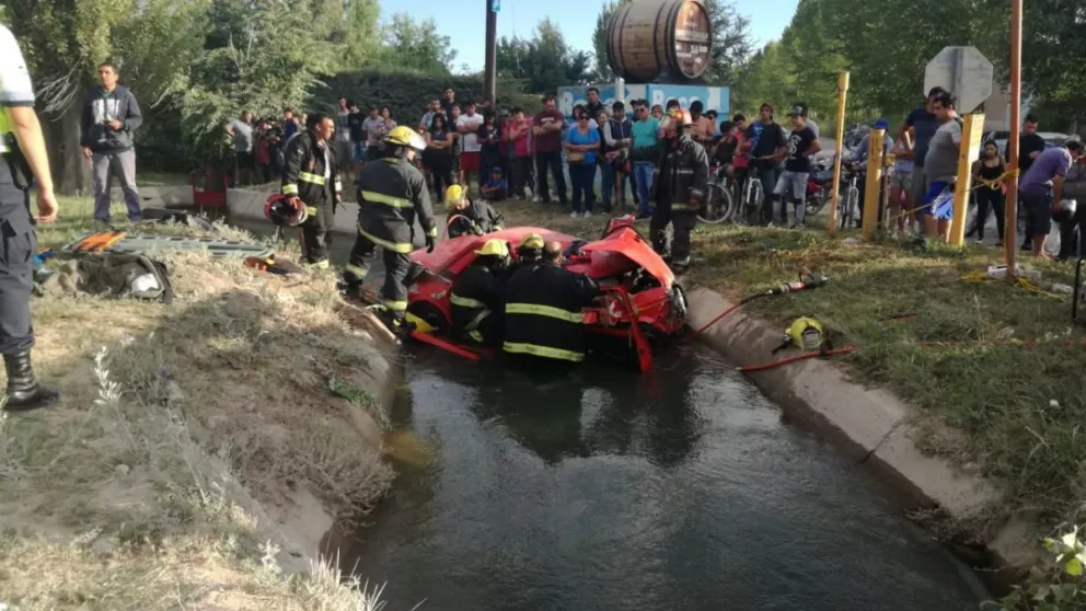 El vehículo cayó a un canal secundario que corre paralelo a la Ruta 22. Personal de bomberos intenta rescatar a la persona.